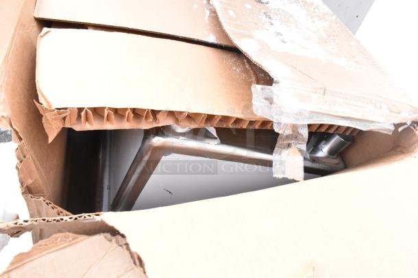 Two new Lancaster Table & Seating Excalibur 3" bar height outdoor table bases in opened box showing minor scratches.