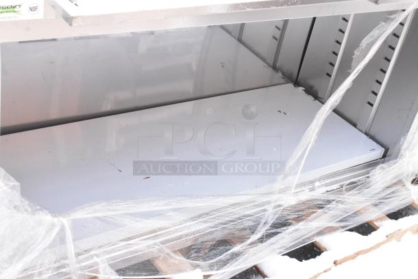 Brand new Regency 600EBTB2472R stainless steel table with enclosed base, sliding doors, drawers, and 6" backsplash, in packaging.