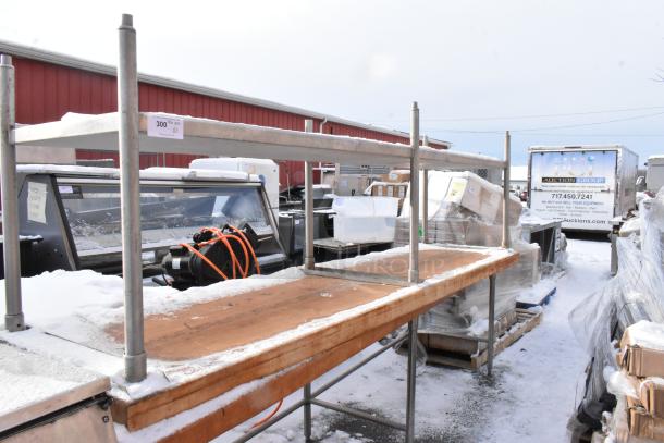Two wooden butcher block tables, one with an under shelf, snowy outdoor setting, auction tag indicating quantity of two.