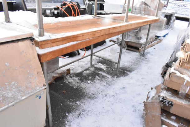 Two wooden butcher block tables, one with an under shelf. Sturdy metal legs, used condition, outdoor setup with snow.