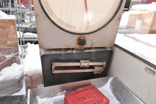 Hobart scale with stand on commercial casters, showing signs of rust and wear, dial and measurement slider visible.