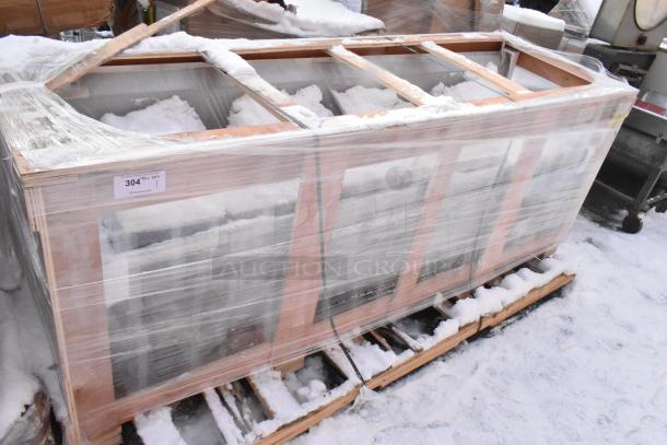 Brand new Regency 600S3162018S stainless steel three-compartment sink with two drainboards, wrapped on pallet with snow.