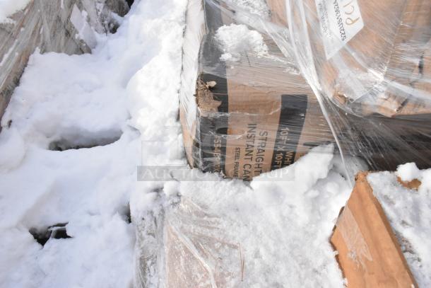 Boxes of brand new scratch and dent items wrapped in plastic on snow, including pop-up canopy tents.