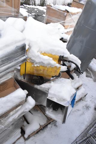 Snow-covered pallet with various items including a yellow shortening shuttle and metal table bases, in scratch and dent condition.