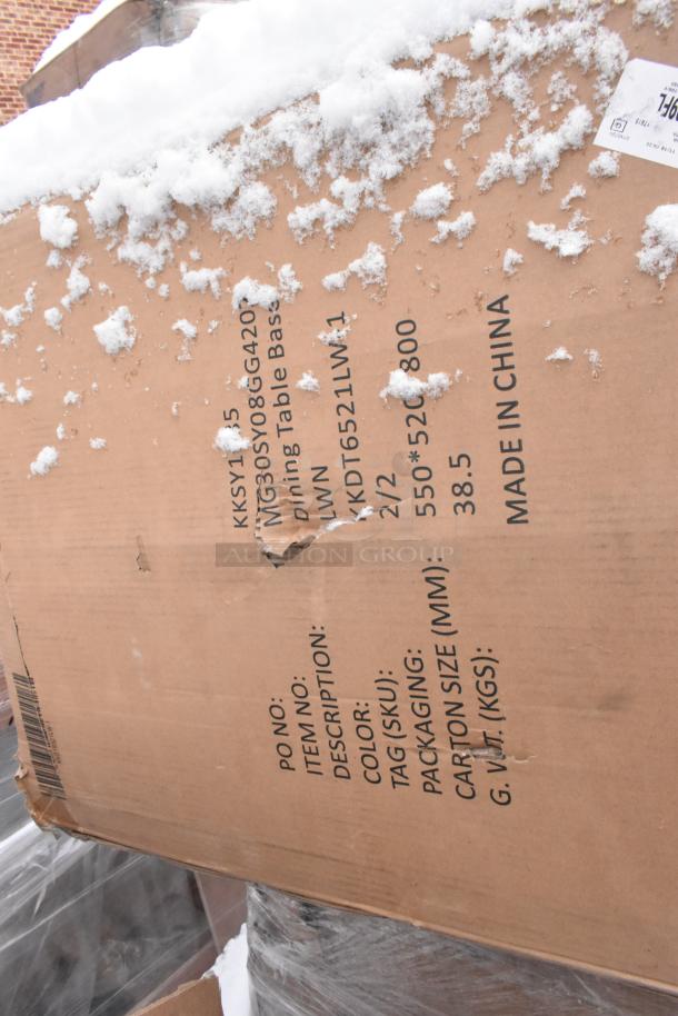 Cardboard box with snow, labeled "Dining Table Base." Includes item number, SKU, dimensions, and "Made in China."