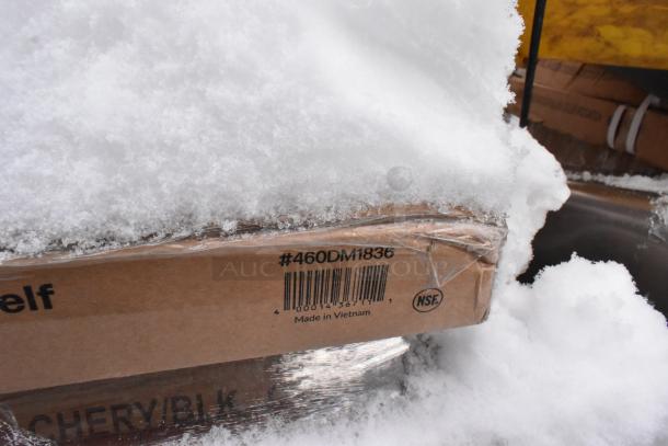 Pallet of various items including drop mat shelves and tabletops, partially snow-covered. Box marked "#460DM1836, Made in Vietnam."