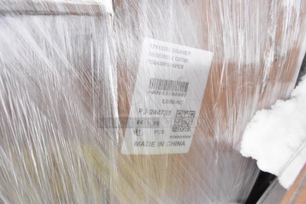 Pallet of new items wrapped in plastic, including Chef Base Drawer Assembly, label shows model CBE60-HC, made in China.