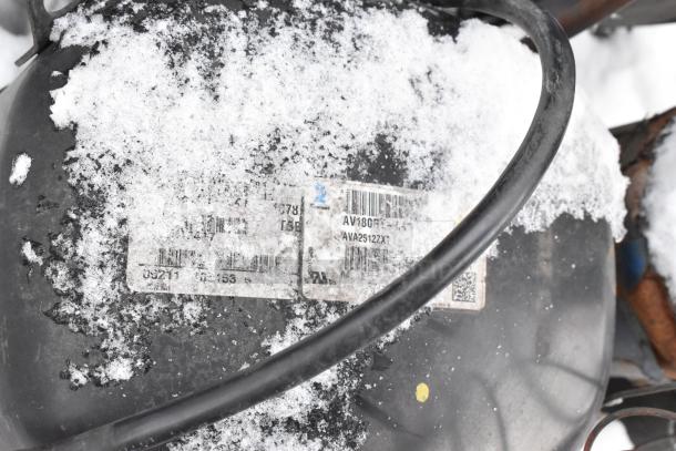 Tecumseh AV180RT commercial compressor, partially covered in snow, showing identification labels and model information.