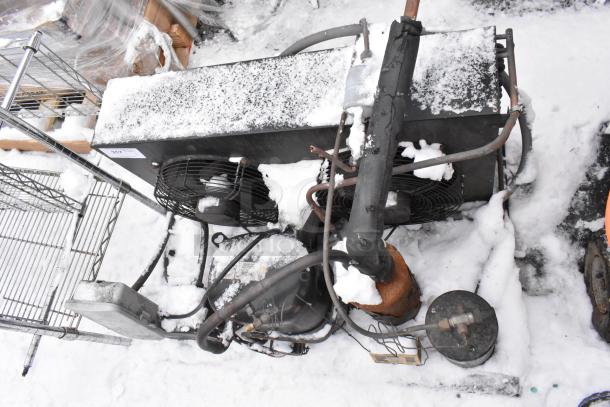 Tecumseh AV180RT Commercial Compressor, snow-covered, dual fans, visible rust, outdoor condition, label with model info.