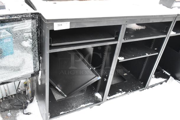 Two black metal counters with shelving, slight wear. Label shows "324 QTY 2." Snow visible, indicating outdoor storage.