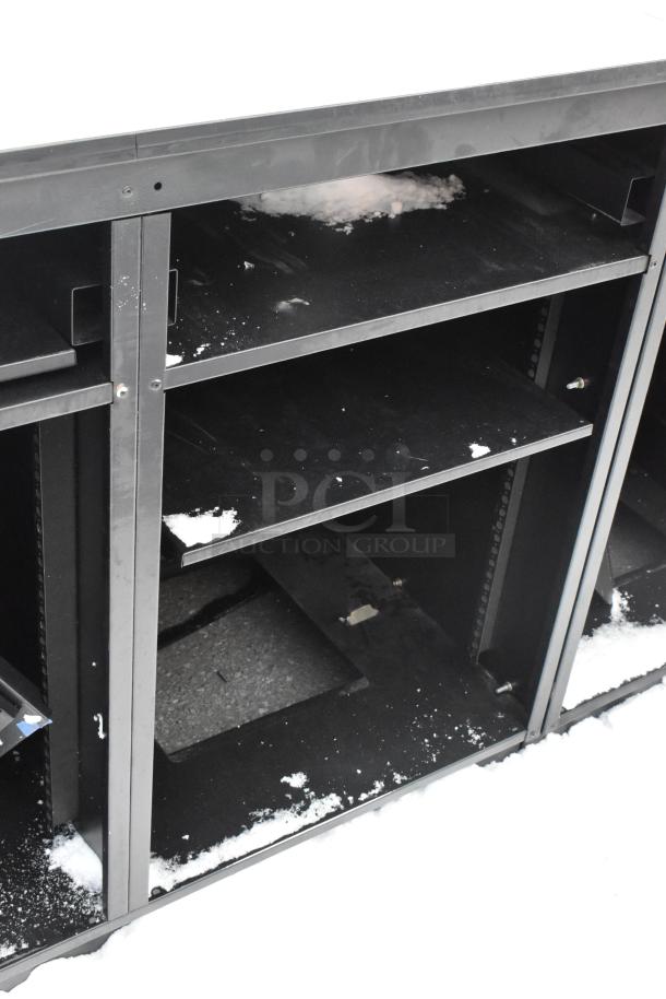 Two black metal counters with open shelving, showing minor signs of wear and outdoor exposure.