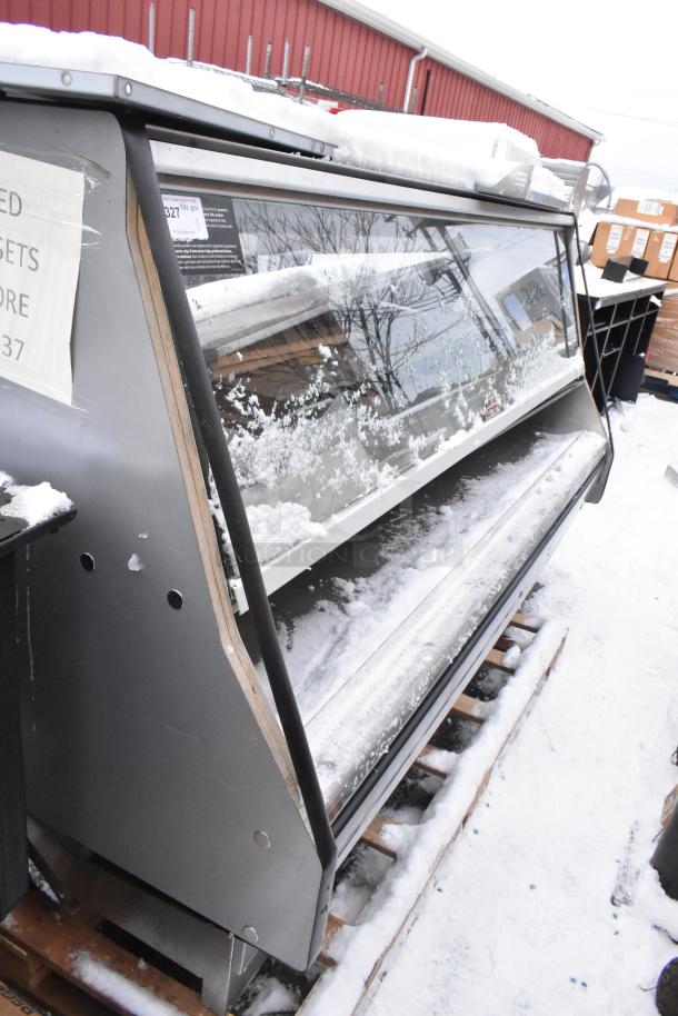 Custom Deli's Equipment heated display case, metal, floor style, snowy exterior, used condition, visible sign inside.