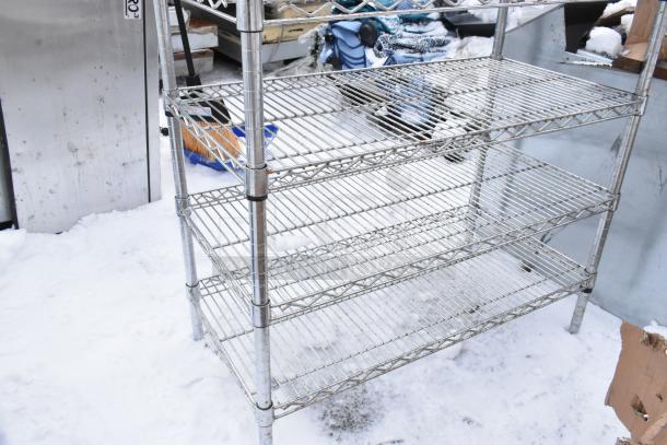 Chrome finish 8 tier wire shelving unit, used, outdoors on snow. BUYER MUST DISMANTLE. Consider freight charges.