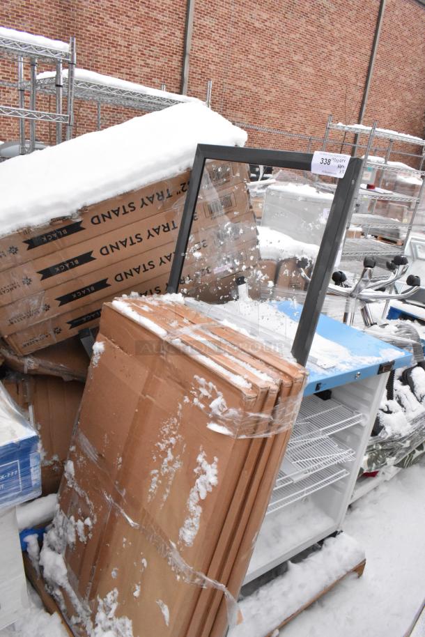 18 new scratch and dent items, including a cooler and Lancaster Table & Seating 32" black wood folding tray stands. Snow-covered.