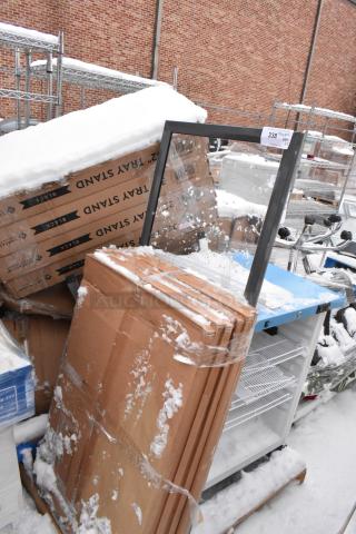 18 new scratch and dent items, including a cooler and Lancaster Table & Seating 32" black wood folding tray stands. Snow-covered.