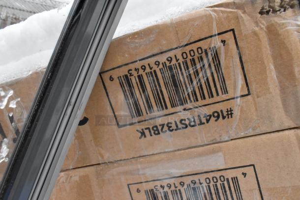 Cardboard box with barcode #164TRS1328BK visible, containing scratch and dent Lancaster Table & Seating items.