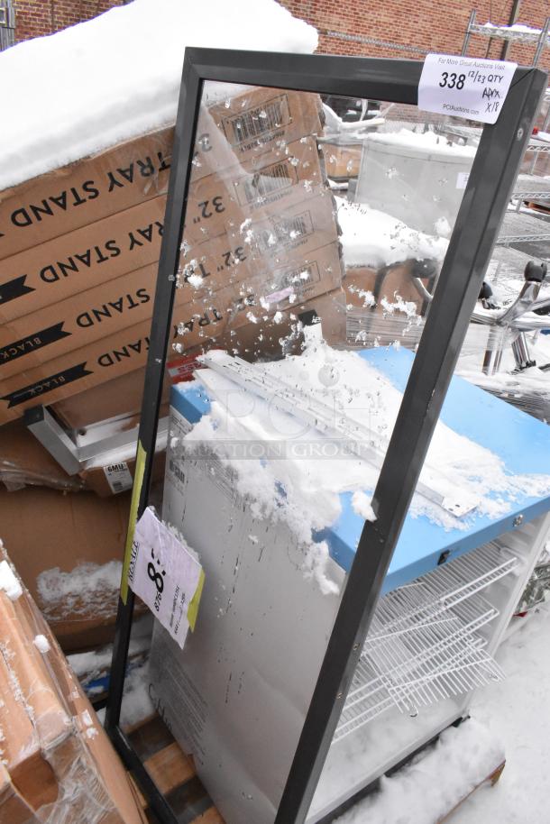 18 scratch and dent items including cooler and Lancaster Table & Seating 32" black wood folding tray stands. Snow covered.