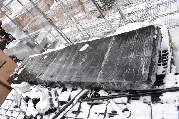 Pallet lot with black poly shelving unit, wrapped in plastic, showing labels. Items are in snowy outdoor setting.