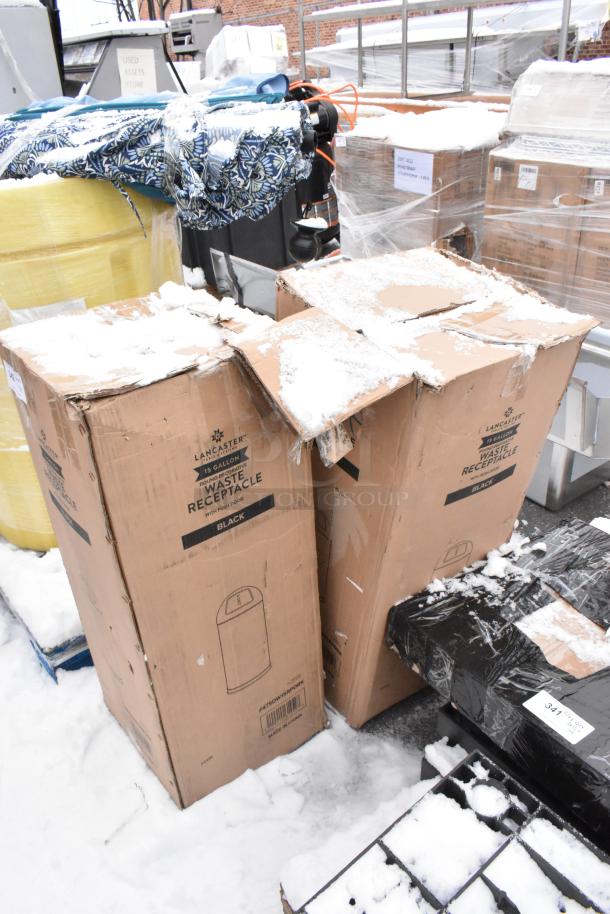 Boxes containing two Lancaster 15-gallon black powder-coated metal trash cans, labeled "waste receptacle with push door."