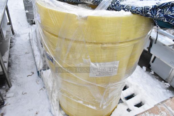 Yellow spill kit barrel secured with plastic wrap, partially covered by patio umbrellas, tags indicating inventory details.