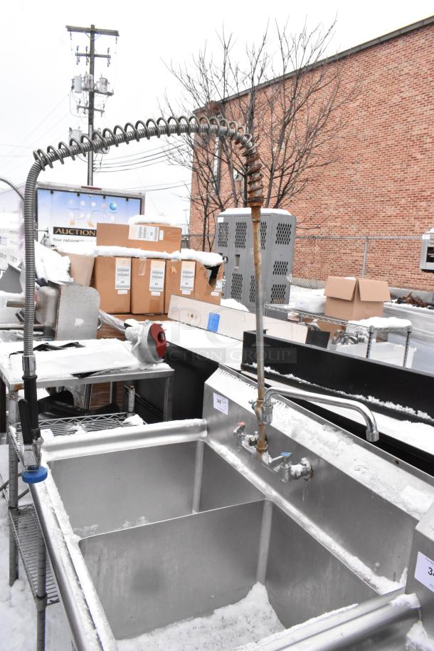 Stainless steel 2-bay sink with faucet, spray nozzle, and handles. Good condition. Ideal for commercial use.