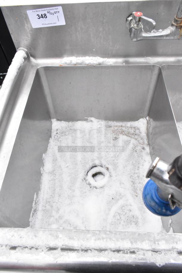 Stainless steel 2 bay sink with faucet, spray nozzle, and handles. Includes auction tag "348". Surface shows signs of wear.