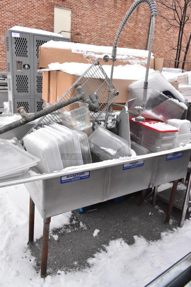 Stainless steel 3 bay sink with left side drain board, filled with poly bins and snow, visible "Sanitize" label.