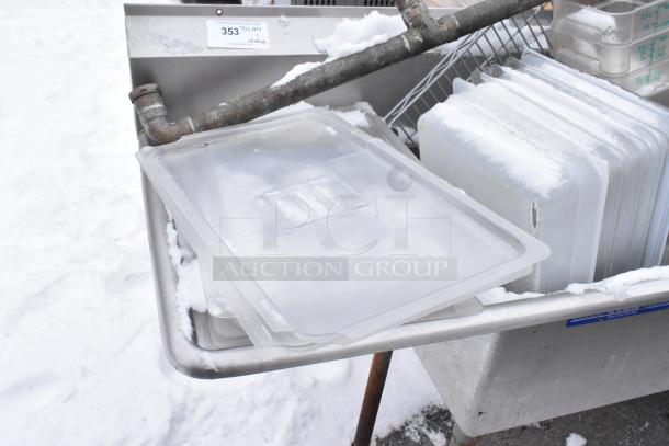 Stainless steel 3-bay sink with left side drain board, containing poly bins. Used condition. Auction label on top edge.
