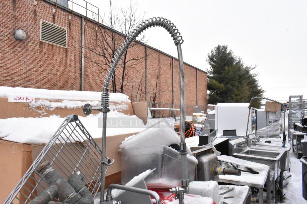 Stainless steel 3-bay sink with left-side drain board, featuring poly bins, some rust and snow, outdoors against a brick wall.