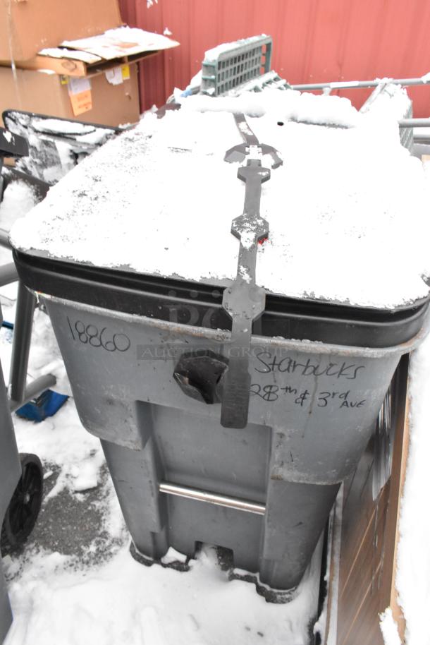 Poly trash can with snow-covered lid, marked "18860" and "Starbucks 28th & 3rd Ave," includes contents like a fan.