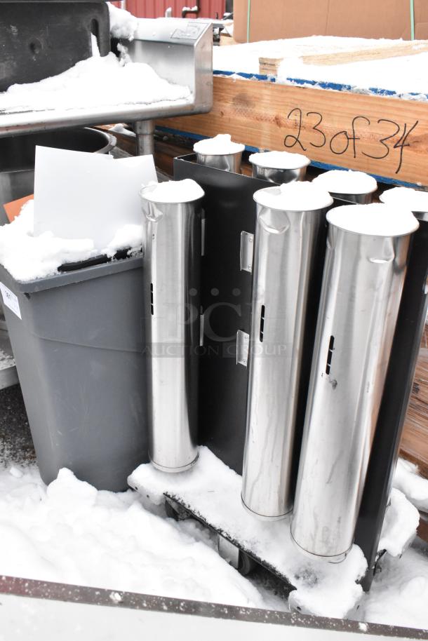 Cup dispenser dolly with four stainless holders and a large gray trash can. Items are lightly dusted with snow.