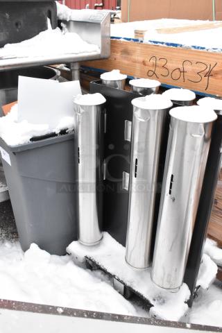 Cup dispenser dolly with four stainless holders and a large gray trash can. Items are lightly dusted with snow.