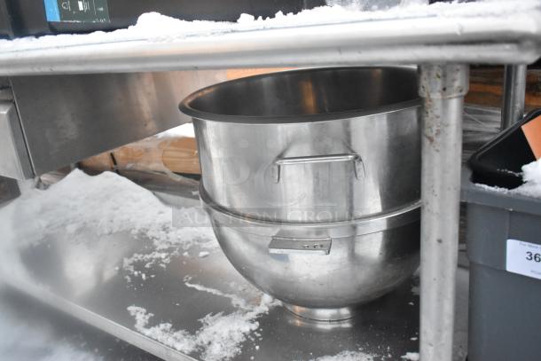 Stainless steel table with under shelf, includes poly trash cans, visible snow, and large mixing bowl. Some surface wear.