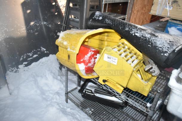 Chrome finish 2-tier wire shelving unit with contents, including a yellow mop bucket. Requires dismantling for transport.