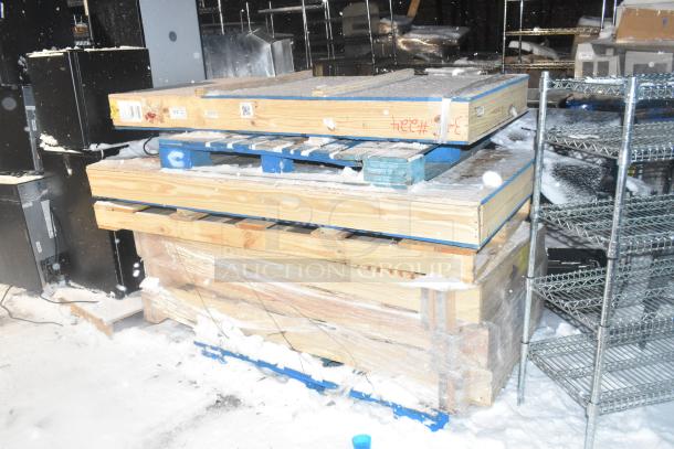 Four brand new items in crates, including Anthony 29-1/16"x66-9/16" door, stacked on pallets, snow-covered.