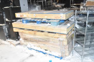 Four brand new items in crates, including Anthony 29-1/16"x66-9/16" door, stacked on pallets, snow-covered.