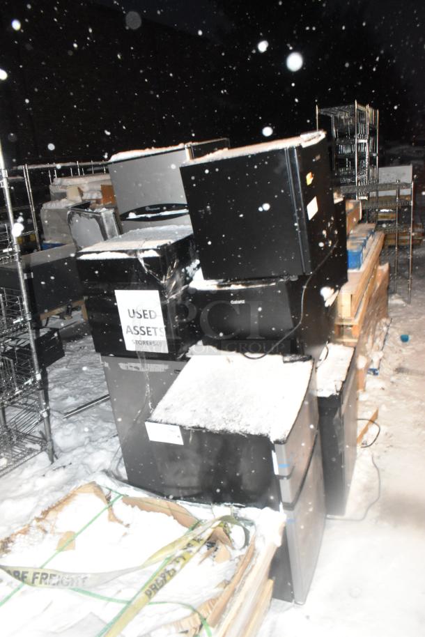 Ten mixed mini coolers, brands include Arctic King, Haier, Galanz. Used condition, snow-covered outside. 115 volts, 1 phase.