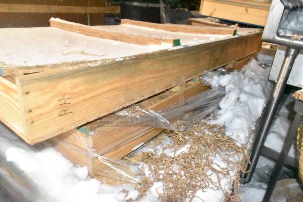 Three brand new items in wooden crates, sealed and wrapped, marked "RH." Snow is visible around the packaging.