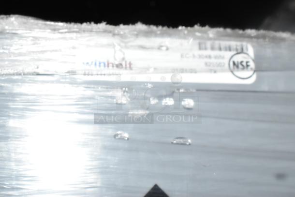 Winholt gray metal cage with visible NSF label and model number. Sealed in plastic. Used for secure storage.