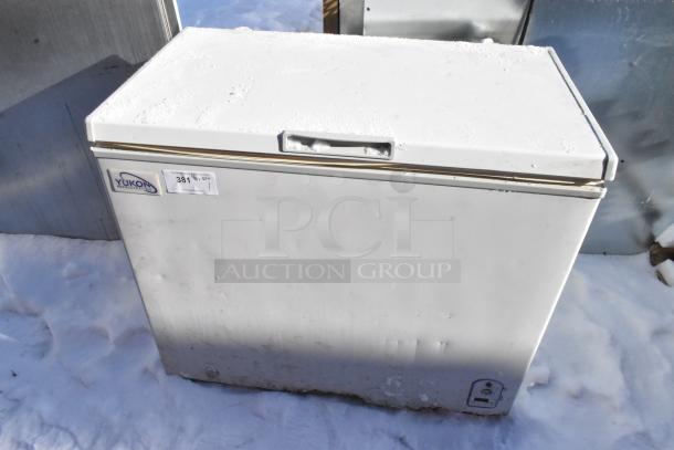 Yukon YCF7 metal chest freezer, 115 volts, 1 phase. Visible Yukon label and auction tag. Appears in used condition.
