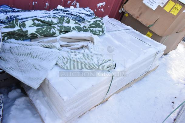 Pallet lot of various items, including folded patio umbrellas with snow covering, visible item label marked "385".