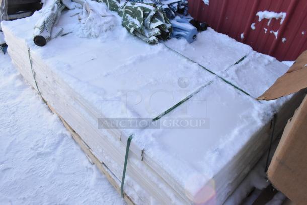Pallet lot with various items including patio umbrellas, covered in snow, shows signs of outdoor storage condition.
