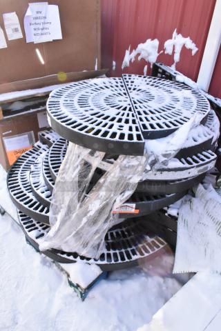 12 black poly semi-circle shelves, stacked and partially wrapped, with snow. Condition appears used. Includes labels.