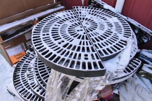 Set of 12 black poly semi-circle shelves, textured surface, outdoor condition, visible packaging and snowy dusting.