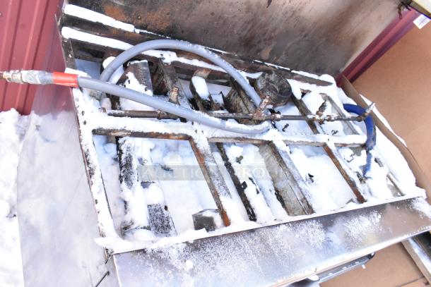 Radiance 10-burner stainless steel commercial range with 2 ovens, over shelf, and backsplash, showing wear and snow.