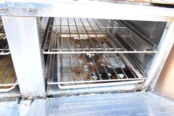 Radiance stainless steel commercial 10 burner range with 2 ovens, visible wear, includes overshelf and backsplash.