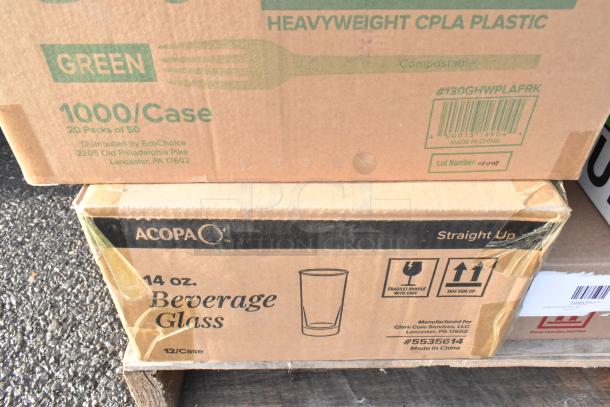 Boxes of new scratch and dent items include EcoChoice heavyweight CPLA plastic forks and Acopa 14 oz. beverage glasses.