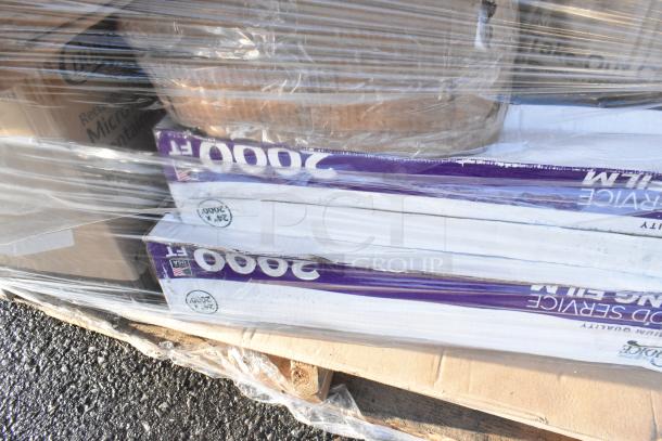 Pallet wrapped with scratch and dent items including food service film, cardboard boxes, and miscellaneous packaging.