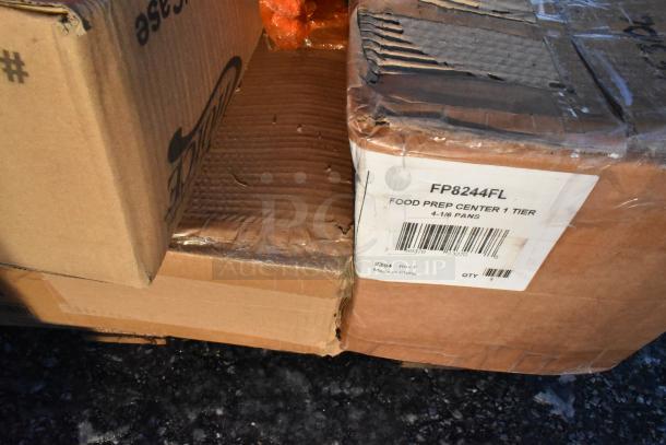 Cardboard boxes labeled "FP8244FL Food Prep Center 1 Tier 4-1/6 Pans." Boxes show minor damage, indicating scratch and dent items.