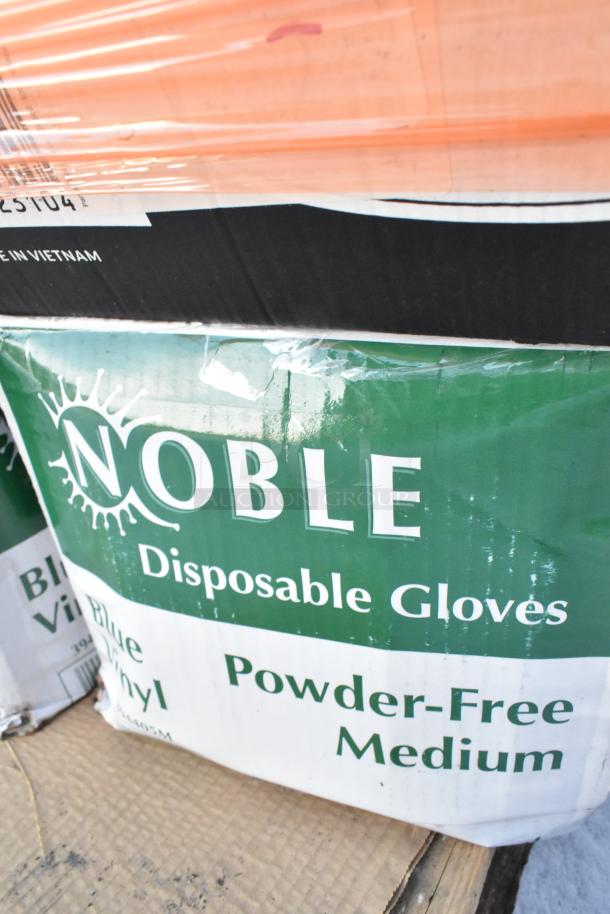 Box of Noble Disposable Gloves, Blue Vinyl, Powder-Free, Medium size, visible scratches and dents, labeled "Made in Vietnam."